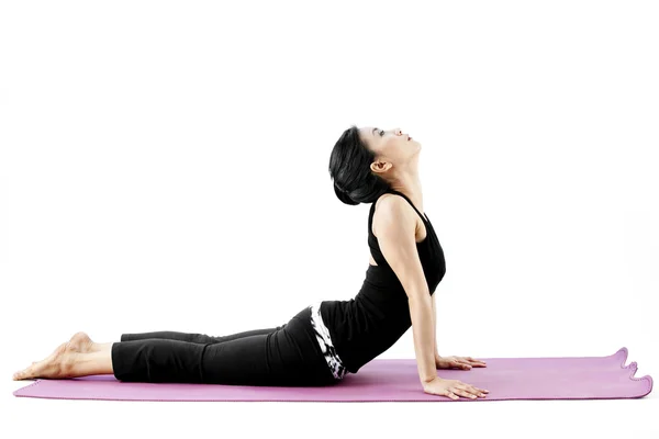 Portrait of a cute young asian female practicing yoga on a mat — Stock Photo, Image