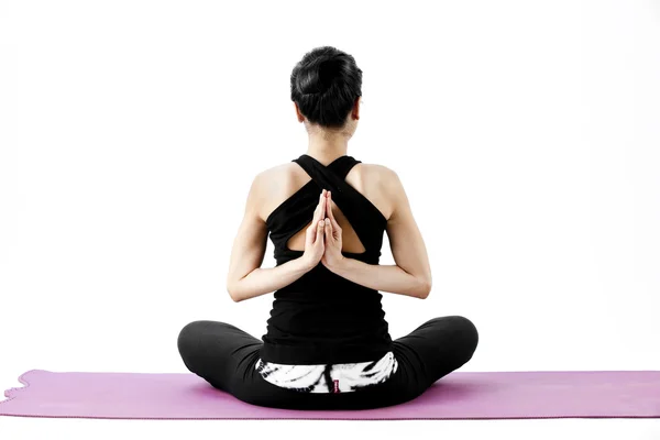 Portrait of a cute young asian female practicing yoga on a mat — Stock Photo, Image