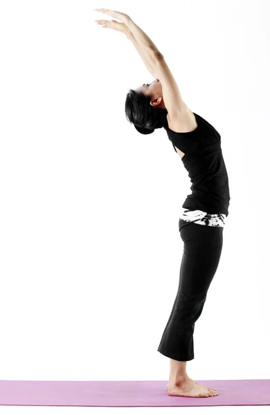 Retrato de una linda joven asiática practicando yoga en una esterilla — Foto de Stock