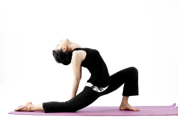 Porträtt av en söt ung asiatisk kvinna utövar yoga på en matta — Stockfoto
