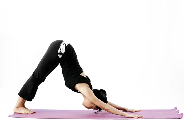 Retrato de una linda joven asiática practicando yoga en una esterilla — Foto de Stock