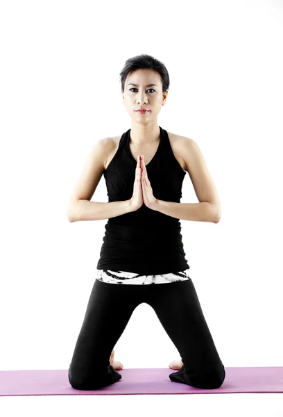 Portrait of a cute young asian female practicing yoga on a mat — Stock Photo, Image