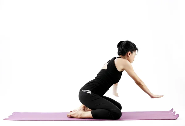 Portret van een schattige jonge Aziatische vrouw beoefenen van yoga op een mat — Stockfoto
