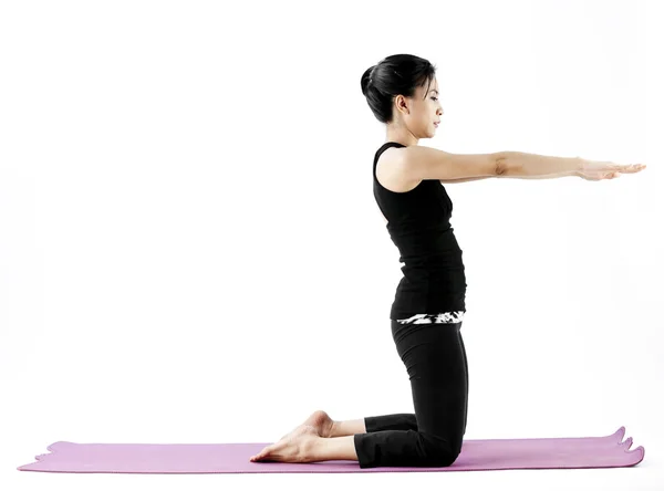 Porträtt av en söt ung asiatisk kvinna utövar yoga på en matta — Stockfoto