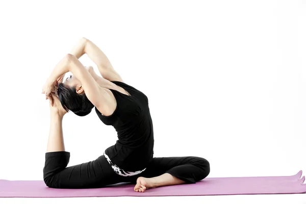 Portrait of a cute young asian female practicing yoga on a mat — Stock Photo, Image