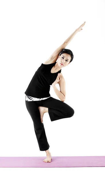 Retrato de una linda joven asiática practicando yoga en una esterilla — Foto de Stock