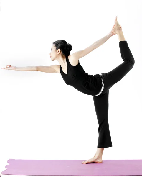 Portret van een schattige jonge Aziatische vrouw beoefenen van yoga op een mat — Stockfoto