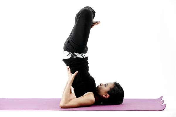 Portrait of a cute young asian female practicing yoga on a mat — Stock Photo, Image