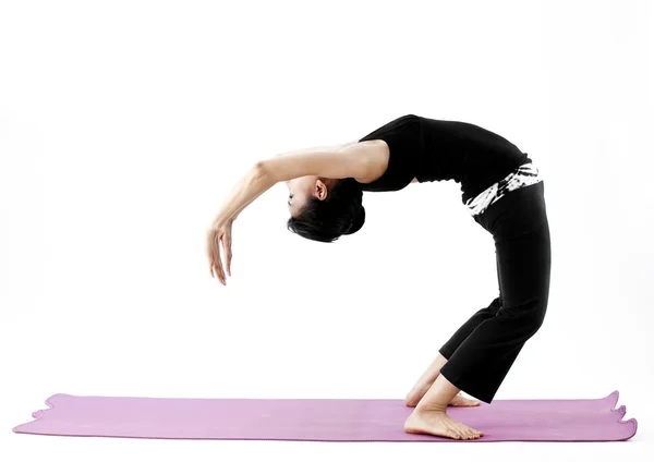 Portrait of a cute young asian female practicing yoga on a mat — Stock Photo, Image