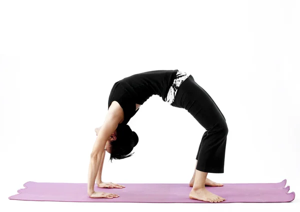 Portrait of a cute young asian female practicing yoga on a mat — Stock Photo, Image