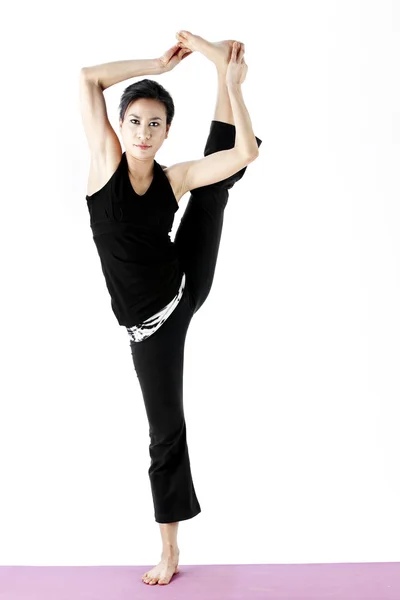 Ritratto di una giovane asiatica carina che pratica yoga su un tappeto — Foto Stock