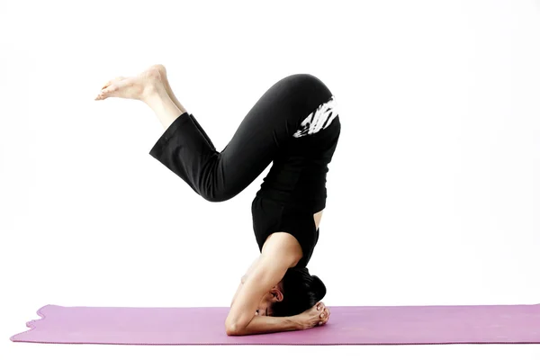 Retrato de una linda joven asiática practicando yoga en una esterilla — Foto de Stock