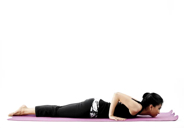 Portrait of a cute young asian female practicing yoga on a mat Royalty Free Stock Photos