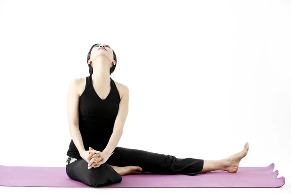 Portrait of a cute young asian female practicing yoga on a mat Royalty Free Stock Photos