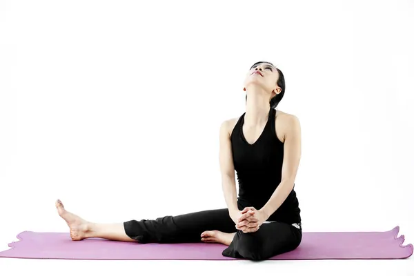 Portrait of a cute young asian female practicing yoga on a mat Stock Image
