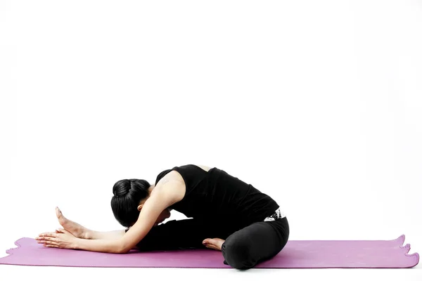 Portrait of a cute young asian female practicing yoga on a mat Stock Image