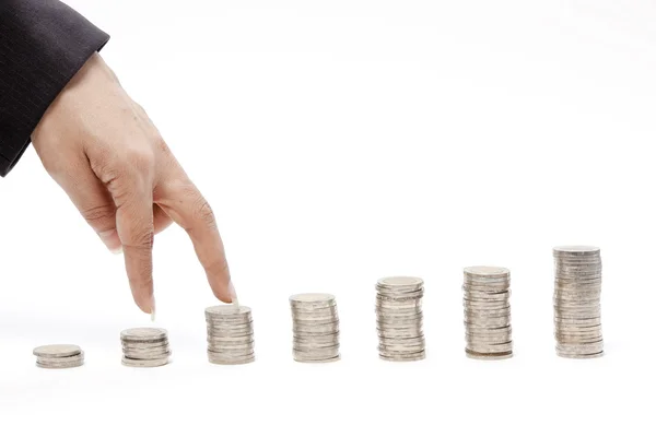 Business hand as finger running on heap of coins — Stock Photo, Image