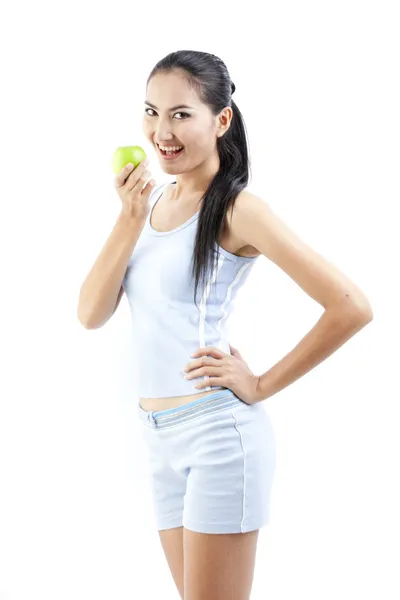 Красивая азиатская женщина ест зеленое яблоко на белом — стоковое фото