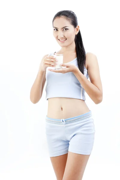 女人喝牛奶。快乐和微笑美丽的年轻女子享受一杯牛奶. — 图库照片