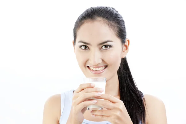 Mulher a beber leite. Feliz e sorridente bela jovem desfrutando de um leite de vidro . — Fotografia de Stock