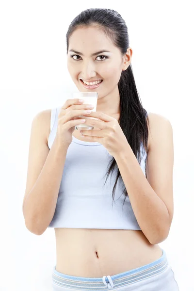 Donna che beve latte. Felice e sorridente bella giovane donna godendo di un latte di vetro . — Foto Stock