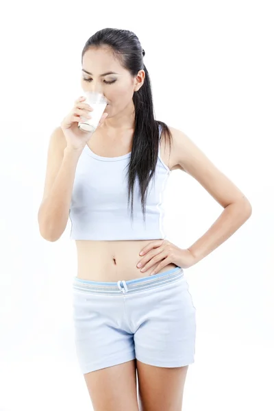 Mujer bebiendo leche. Feliz y sonriente hermosa joven disfrutando de una leche de vidrio . — Foto de Stock