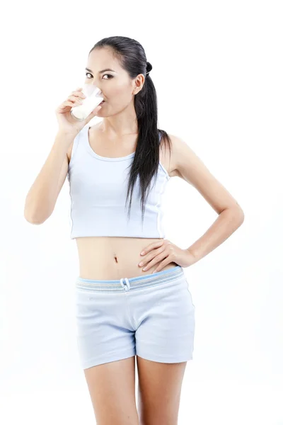 Mujer bebiendo leche. Feliz y sonriente hermosa joven disfrutando de una leche de vidrio . — Foto de Stock