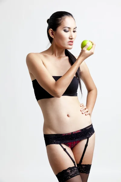 Shot of a sexy woman in black hand holding apple — Zdjęcie stockowe