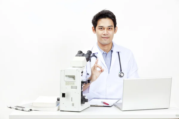 Närbild av läkare vid sitt skrivbord framför dator — Stockfoto