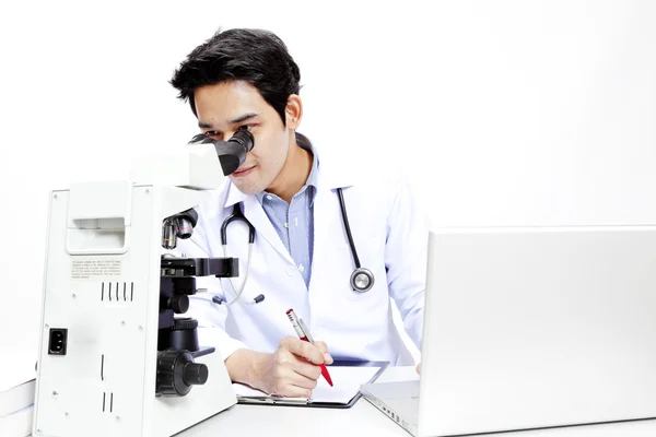 Närbild av läkare vid sitt skrivbord framför dator — Stockfoto