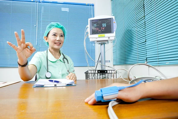 Kadın doktor ok işareti hastayla gösterilen — Stok fotoğraf