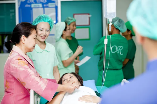 Medical workers moving patient to operating room — Stock Photo, Image