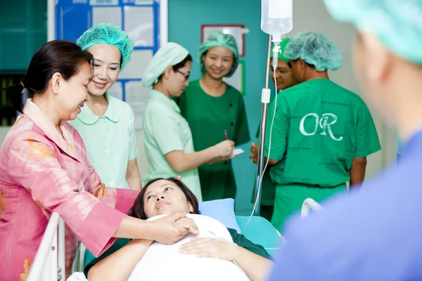 Medical workers moving patient to operating room — Stock Photo, Image