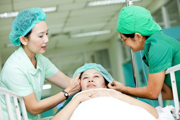 Medizinisches Personal bringt Patient auf Krankenhauswagen in den Operationssaal — Stockfoto