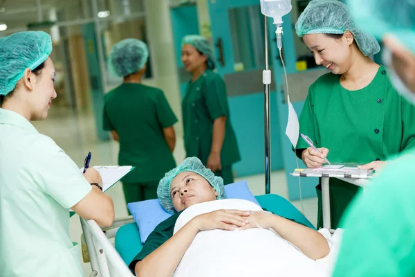 Operatore medico che sposta il paziente sul carrello dell'ospedale in sala operatoria — Foto Stock