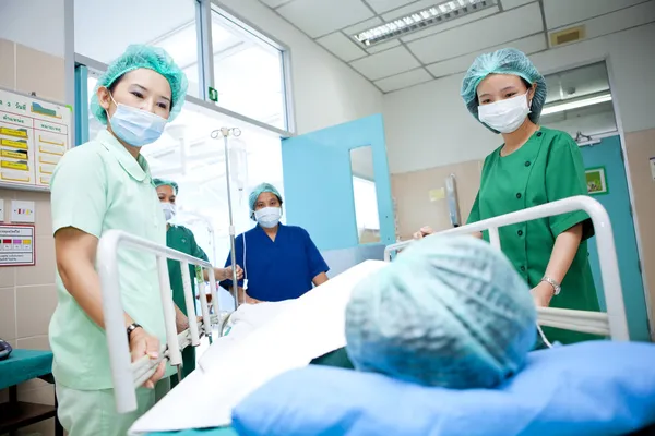 Рабочие перевозят пациента в операционную — стоковое фото
