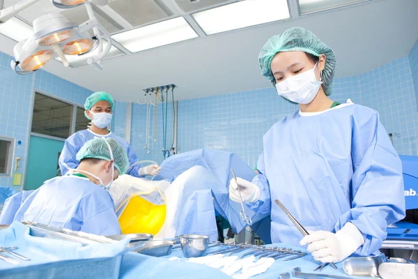 Médecin en salle d'opération avec son équipe — Photo