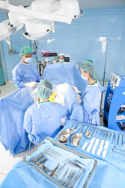 Plusieurs chirurgiens entourant le patient sur la table d'opération pendant leur travail — Photo