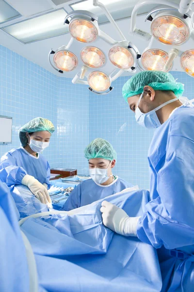 Médecin en salle d'opération avec son équipe — Photo