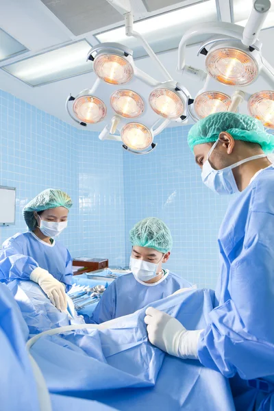 Médecin en salle d'opération avec son équipe — Photo