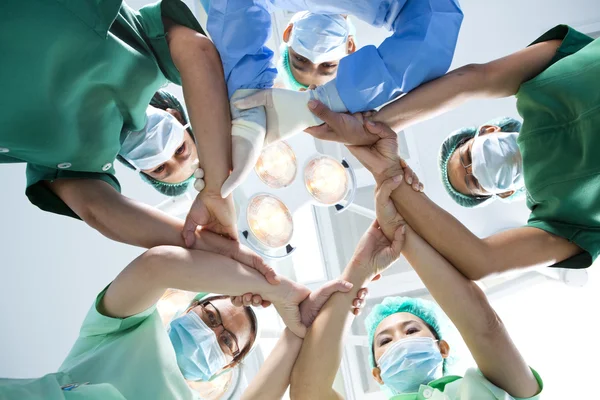 Небольшая группа врачей, объединяющих руки, взгляд под углом зрения муравья . — стоковое фото