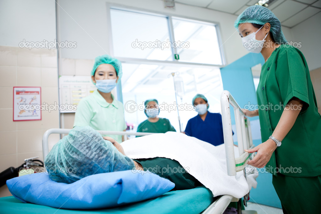 Workers moving patient to operating room