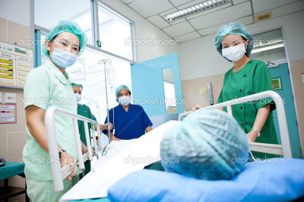Workers moving patient to operating room
