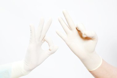 el ok işareti üzerine beyaz izole gösterilen medikal eldiven giymiş