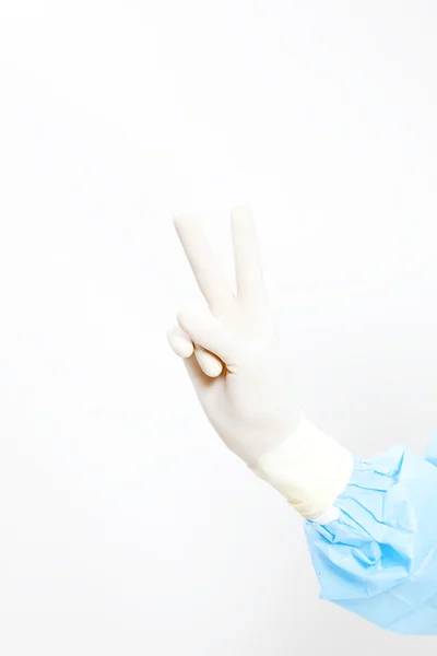 Mano vestida con guante médico mostrando signo de victoria aislado en blanco —  Fotos de Stock