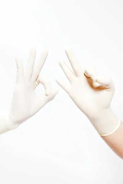 Mano vestida con guante médico que muestra signo OK aislado en blanco — Foto de Stock