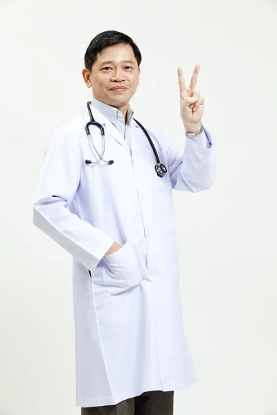 Retrato de médico maduro sonriente, mostrando signo de mano — Foto de Stock