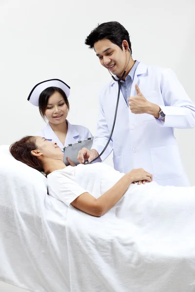 Retrato de un médico con sus compañeros de trabajo hablando con un paciente en el fondo —  Fotos de Stock