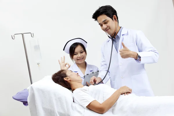 Retrato de un médico con sus compañeros de trabajo hablando con un paciente en el fondo —  Fotos de Stock