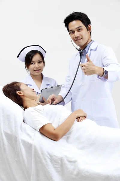 医生与他的同事跟一个病人在背景中的肖像 — 图库照片